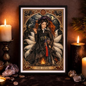 Puede incluir: Una impresión artística enmarcada titulada The Devil que muestra una figura de zorro de varias colas con un hanbok negro, sosteniendo una pipa humeante. La ilustración incluye un pentagrama, murciélagos y un motivo de llama en un borde ornamentado.