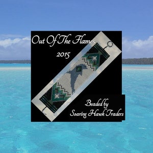 Könnte beinhalten: Ein Armband aus Perlen mit einem schwarzen, weißen und grünen Design. Das Armband zeigt ein Vogelmotiv und den Text "Out Of The Flames 2015". Das Armband ist von Soaring Hawk Traders gefertigt.