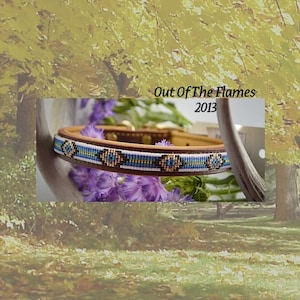 May include: A brown leather dog collar with a beaded design in blue, white, and gold. The beads form a geometric pattern. The collar is labeled "Out Of The Flames 2013".