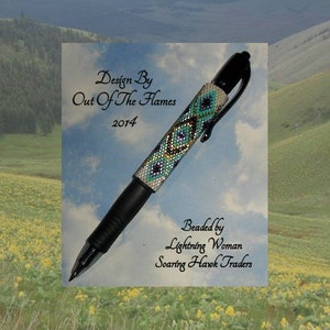 Op de afbeelding: Een zwarte pen met een kralenontwerp in tinten blauw, groen, wit en goud. De pen is versierd met een ruitpatroon. De tekst "Design By Out Of The Flames 2014" en "Beaded by Lightning Woman Soaring Havok Traders" is gedrukt op de witte achtergrond.