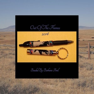 Op de afbeelding: Een set met een geperst pen en sleutelhanger met een zwart-wit ontwerp. De pen en sleutelhanger zijn versierd met gekleurde kralen. De tekst "Out of the Flames 2014 Beaded by Barbara Ford" staat op de afbeelding.