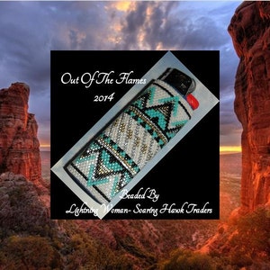 Könnte beinhalten: Ein weißer, schwarzer und türkisfarbener, perlenbesetzter Feuerzeugüberzug mit geometrischem Muster. Der Überzug ist mit "Out Of The Flames 2014" und "Beaded By Lightning Woman - Soaring Hawk Traders" beschriftet.