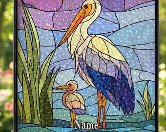 Könnte beinhalten: Buntglasfenster mit einem Reiher und einem kleineren Vogel in einer Sumpflandschaft. Die Vögel haben orangefarbene Schnäbel und Beine, mit blauem, lila und weißem Gefieder. Der Hintergrund ist ein Mosaik aus blauen und lila Farbtönen mit grünen Schilf.