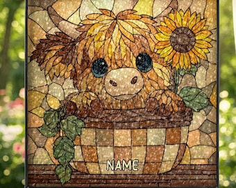 Könnte beinhalten: Glasfenster mit einer Highland-Kuh in einem Korb mit einer Sonnenblume. Das Kunstwerk hat eine braune, gelbe und grüne Farbpalette. Das Wort "NAME" ist auf dem Korb aufgedruckt.