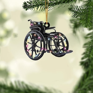 May include: Black wheelchair ornament with colorful lights, perfect for a Christmas tree. The wheelchair has a personalized name tag that says "Name".