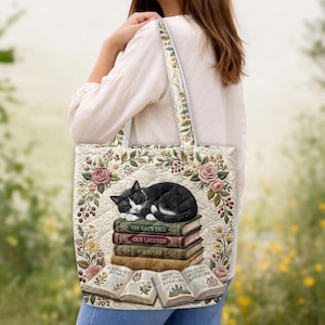 May include: A quilted tote bag featuring a black and white cat sleeping on a stack of books. The books are titled The Cat's Tale, Old Legends, Whispers, and Stella. Below are open books titled A Scholar's Botany and Tales of Mystery & Folklore.