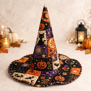 May include: A quilted witch hat featuring a patchwork design with black, orange, and purple fabric squares. The pattern includes illustrations of jack-o'-lanterns, black cats, crescent moons, spiderwebs, bats, stars, and small floral motifs.