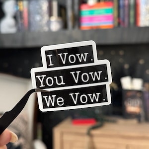 May include: Black and white sticker with the text "I Vow. You Vow. We Vow."