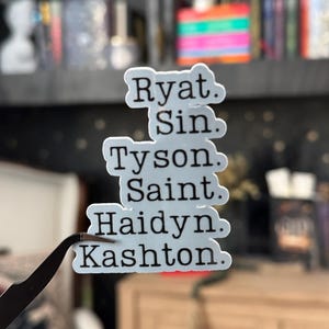 May include: A white sticker with black text listing the names Ryat, Sin, Tyson, Saint, Haidyn, and Kashton.