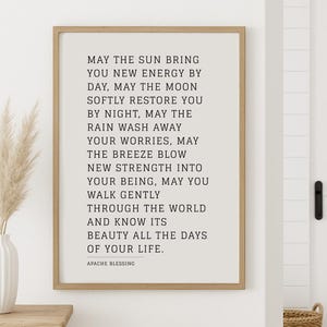 Peut inclure: Une impression encadrée avec un fond blanc et du texte noir. Le texte est une citation sur la recherche de la force et de la beauté dans la vie. La citation se lit comme suit : "Que le soleil vous apporte une nouvelle énergie de jour, que la lune vous restaure doucement la nuit, que la pluie emporte vos soucis, que la brise vous apporte une nouvelle force dans votre être, que vous puissiez marcher doucement à travers le monde et connaître sa beauté tous les jours de votre vie. Bénédiction Apache."