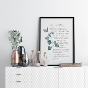 Könnte beinhalten: Ein gerahmter Druck mit weißem Hintergrund und grünem Laub. Der Druck zeigt das Vaterunser, "Vater unser im Himmel..."