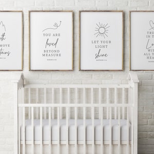 May include: Four framed prints with inspirational quotes and illustrations. The prints feature quotes about faith, love, light, and trust. The prints are hung on a white brick wall above a white crib.