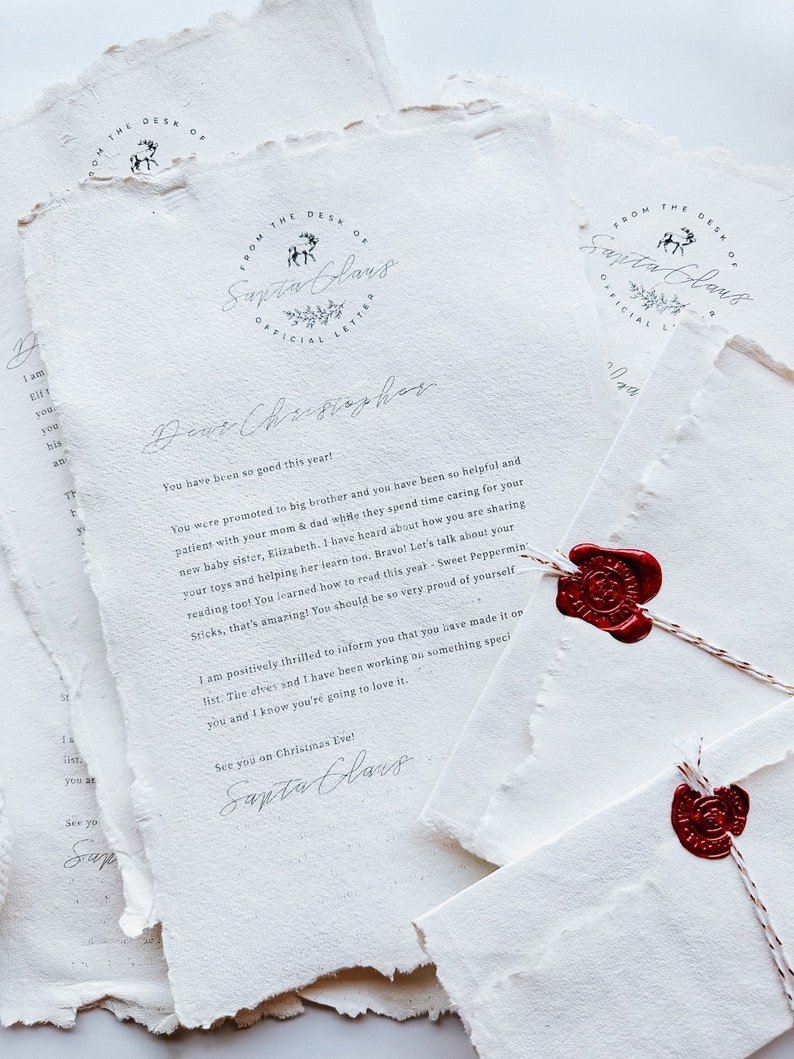 May include: A stack of textured white paper with handwritten text, featuring a circular logo that reads "From the Desk of Santa Claus." The letters are sealed with red wax stamps and tied with twine. The theme is a letter from Santa.