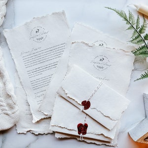 May include: Off-white stationery set featuring torn edges, a wax seal, and the text "From the Desk of Santa Claus." The set includes letters and envelopes tied with twine. A festive holiday theme.