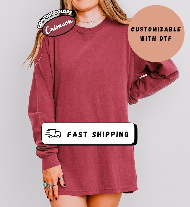 May include: Crimson long-sleeve shirt with the text "Comfort Colors" and "Customizable with DTF". The shirt also has the text "Fast Shipping" on it.