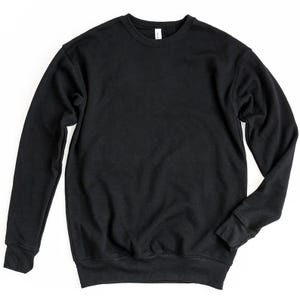 May include: A solid black crewneck sweatshirt. The long-sleeved top has a classic design with a ribbed hem and cuffs. The sweatshirt is made of a soft material and is suitable for casual wear. The tag is visible at the back of the neck.