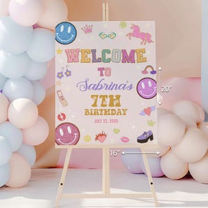 Puede incluir: Un letrero rectangular de bienvenida de cumpleaños de 40,64 cm por 50,8 cm, con fondo rosa claro y gráficos coloridos que incluyen caras sonrientes, un unicornio y el texto Welcome to Sabrina's 7th Birthday July 23, 20XX.