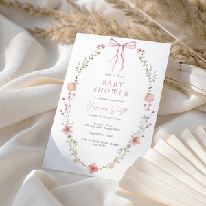 Looking for a sophisticated Pink Bow Baby Shower Invitation Template? This editable coquette girl baby shower invite features a dusty blush pink ribbon and minimalist hand-drawn floral accents. Perfect for a French Chinoiserie or Toile themed sprinkle. This high-quality digital download is easy to customize for a timeless, elegant baby girl celebration. Buy now for a printable or mobile-friendly invitation that fits the trendy coquette aesthetic and minimalist wildflower style.