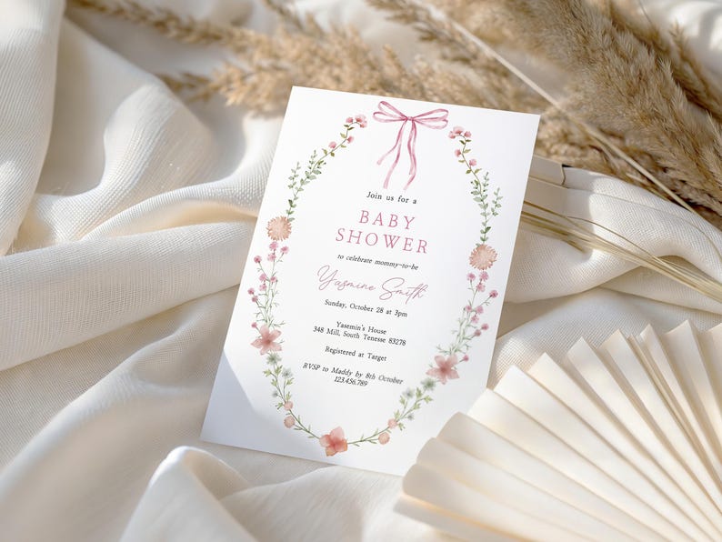 Looking for a sophisticated Pink Bow Baby Shower Invitation Template? This editable coquette girl baby shower invite features a dusty blush pink ribbon and minimalist hand-drawn floral accents. Perfect for a French Chinoiserie or Toile themed sprinkle. This high-quality digital download is easy to customize for a timeless, elegant baby girl celebration. Buy now for a printable or mobile-friendly invitation that fits the trendy coquette aesthetic and minimalist wildflower style.
