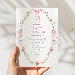 Looking for a sophisticated Pink Bow Baby Shower Invitation Template? This editable coquette girl baby shower invite features a dusty blush pink ribbon and minimalist hand-drawn floral accents. Perfect for a French Chinoiserie or Toile themed sprinkle. This high-quality digital download is easy to customize for a timeless, elegant baby girl celebration. Buy now for a printable or mobile-friendly invitation that fits the trendy coquette aesthetic and minimalist wildflower style.