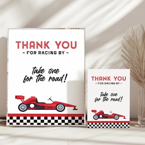 Könnte beinhalten: Zwei weiße Karten mit roten und schwarzen Akzenten. Die größere Karte lautet "THANK YOU - FOR RACING BY - Take one for the road!" und zeigt eine rote Rennwagen-Grafik. Die kleinere Karte hat das gleiche Design.