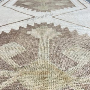 May include: A beige and brown patterned runner rug. The rug features geometric designs in shades of brown and beige. The rug's texture is visible, suggesting a woven construction. The rug is rectangular and appears to be made of natural fibres.