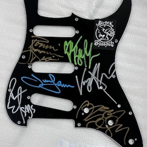 Stratocaster guitar pickguard signed by Black Sabbath Ozzy Osbourne, Tony Iommi, Bill Ward, Geezer Butler Ronnie James Dio