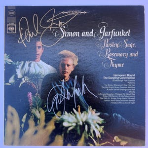 Puede incluir: Portada de álbum de vinilo vintage de "Parsley, Sage, Rosemary and Thyme" de Simon and Garfunkel. La portada presenta un fondo oscuro con el nombre de la banda y el título del álbum en una elegante escritura. La portada del álbum incluye las firmas de Paul Simon y Art Garfunkel.