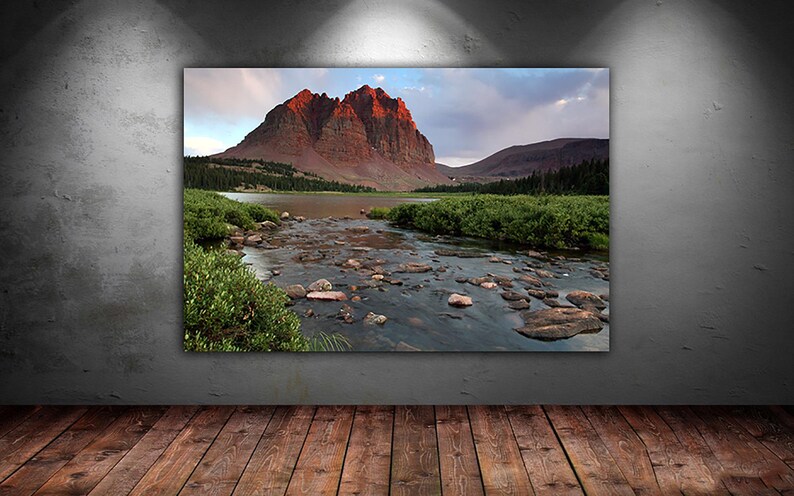 a serene landscape with a river flowing through a mountainous terrain, surrounded by lush greenery and rocky banks.