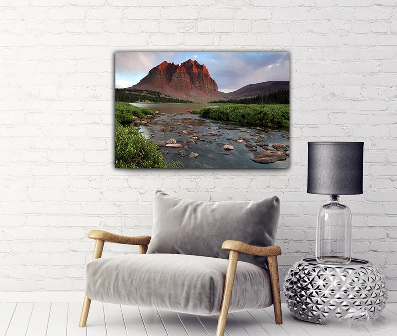 a serene landscape with a mountain range in the background and a river flowing through the foreground.