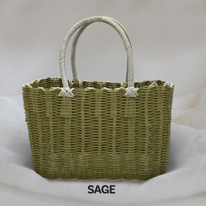 Puede incluir: Una bolsa de mano tejida de color verde salvia con asas blancas. La bolsa tiene una forma rectangular con bordes redondeados. La palabra "SAGE" est&aacute; impresa en negro debajo de la bolsa.