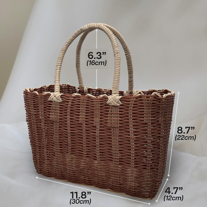 Puede incluir: Una bolsa de mano tejida de color marr&oacute;n y beige con dos asas. La bolsa mide 30 cm de ancho, 22 cm de alto y 12 cm de profundidad.