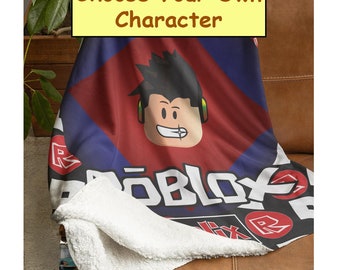 May include: A red, blue, and black fleece blanket with the word "ROBLOX" printed on it. The blanket features a cartoon character with black hair and headphones. The text "Choose Your Own Character" is printed on a yellow rectangle.