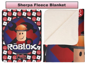 May include: A black and red fleece blanket with a white sherpa lining. The blanket features a Roblox logo, a character with a wrench and hammer, and the text "Felix".