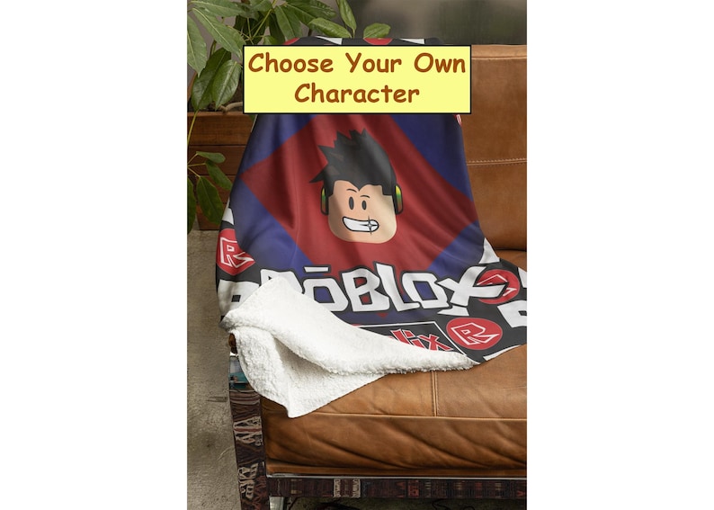 Peut inclure: Une couverture en polaire rouge, bleue et noire avec le mot "ROBLOX" imprim&eacute; dessus. La couverture repr&eacute;sente un personnage de dessin anim&eacute; avec des cheveux noirs et des &eacute;couteurs. Le texte "Choose Your Own Character" est imprim&eacute; sur un rectangle jaune.
