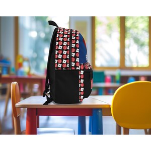 Pu&ograve; includere: Uno zaino nero con un motivo a scacchi rosso, bianco e blu. Lo zaino ha una tasca con cerniera sul davanti e un ampio scomparto principale.