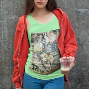 Könnte beinhalten: Ein limegrünes Tanktop mit einem grafischen Aufdruck einer Gruppe von Menschen, die auf einem Stier reiten. Der Text "T. Parker" ist unten auf dem Shirt aufgedruckt.