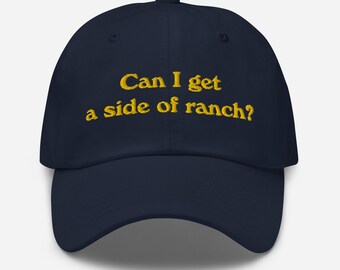 Puede incluir: Una gorra de béisbol azul marino con el texto "Can I get a side of ranch?" bordado en amarillo.