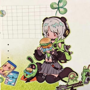 Op de afbeelding: Een kleurrijke stickerpagina met een stripfiguur die een hamburger eet, omringd door voedsel- en accessoirestickers. Het personage draagt een koptelefoon en een groene outfit. Andere stickers zijn een drankje, een pistool en een klavertje vier.