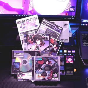 Puede incluir: Una colección de CDs, DVDs y materiales promocionales con ilustraciones de estilo anime. Los artículos incluyen el texto "ANGELS OF VISION", "RECORD AGENT" y "ZENLESS ZONE ZERO". La paleta de colores es predominantemente púrpura y negro.