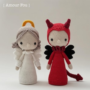 May include: A crocheted angel doll with a white dress and yellow halo stands next to a crocheted devil doll wearing a red costume with black wings and a tail.