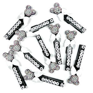 May include: A set of 12 black hair clips with white bows and a Mickey Mouse head design. Each clip has the word "SUMMIT" written on it in white letters.