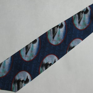 May include: A blue silk tie with a repeating pattern of a loon in a circle with the text "Welcome to the Lake" around the loon.