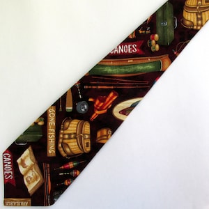 May include: A brown silk tie with a fishing theme. The tie features a variety of fishing equipment, including rods, reels, lures, and a canoe. The tie also has the words "Gone Fishing" and "Canoes" printed on it.