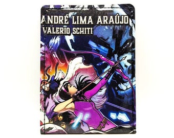 May include: A colorful wallet featuring a comic book style illustration of a female superhero with a bow and arrow. The text "ANDRE LIMA ARAUJO VALERIO SCHITI" is printed on the wallet.