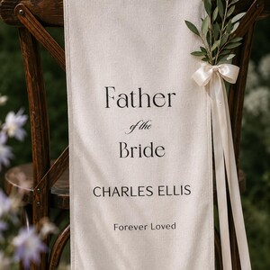 Father of the Bride memorial chair banner displayed outdoors in romantic garden wedding setting