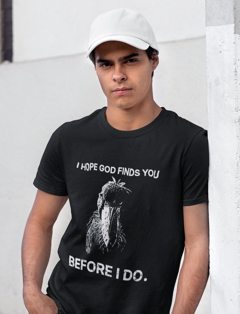 May include: A black t-shirt with a white graphic of a bird and the text "I hope God finds you before I do."