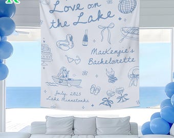 Könnte beinhalten: Weiße Stoff-Wandbehang mit blauem Text und Illustrationen. Der Text lautet "Love on the Lake" und "Mackenzie's Bachelorette" mit dem Datum Juli 2025 und Lake Minnetonka. Das Design umfasst einen Schwan, Kuchen, Boot und andere thematische Grafiken.