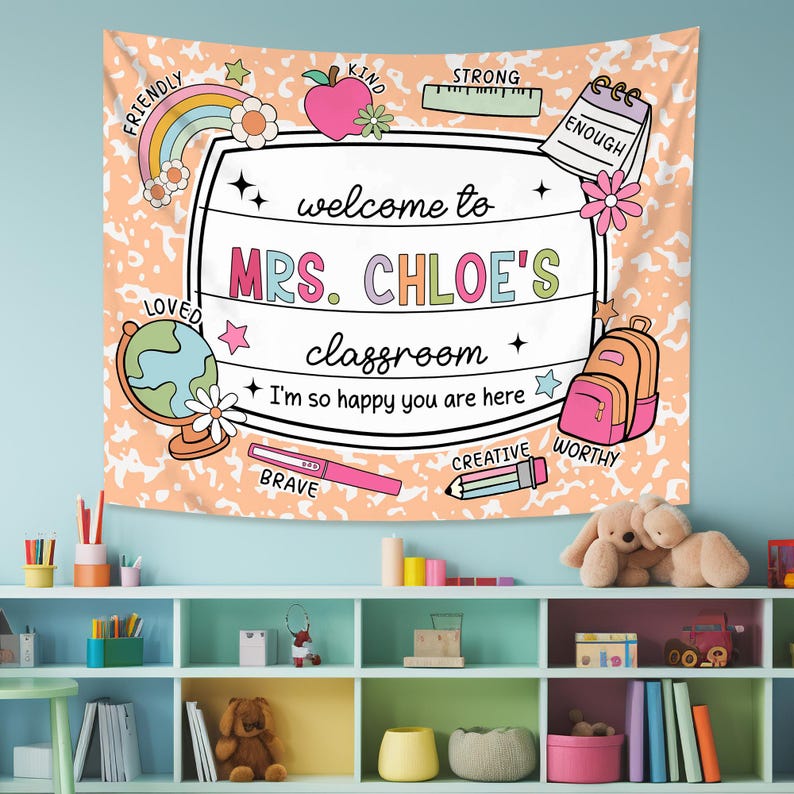 May include: A peach-colored classroom tapestry with a white border and a welcome sign that reads "Welcome to Mrs. Chloe's Classroom". The sign is surrounded by colorful illustrations of school supplies, including a rainbow, a globe, a pencil, a ruler, a backpack, and a notebook. The tapestry also features the words "Friendly", "Kind", "Strong", "Enough", "Loved", "Brave", "Creative", and "Worthy" in a colorful font.