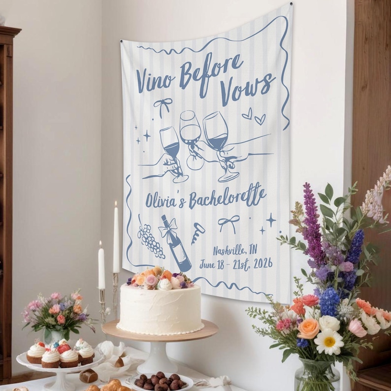 Puede incluir: Una pancarta de tela blanca con rayas verticales azules y texto azul que dice Vino Before Vows, Olivia's Bachelorette, y Nashville, TN June 18-21st, 2026. El dise&ntilde;o presenta ilustraciones de copas de vino, una botella y lazos.